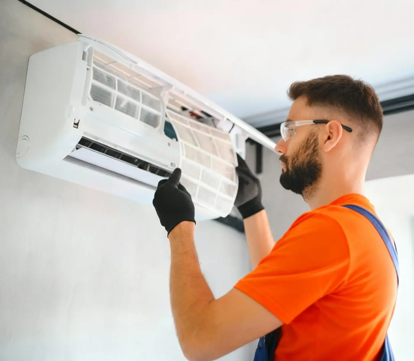 Technician maintaining a wall-mounted air-conditioning unit