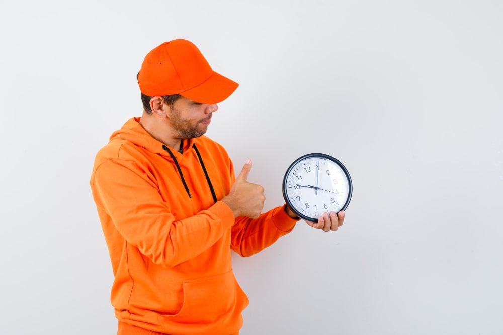 Engineer holding a clock while discussing a planned service visit