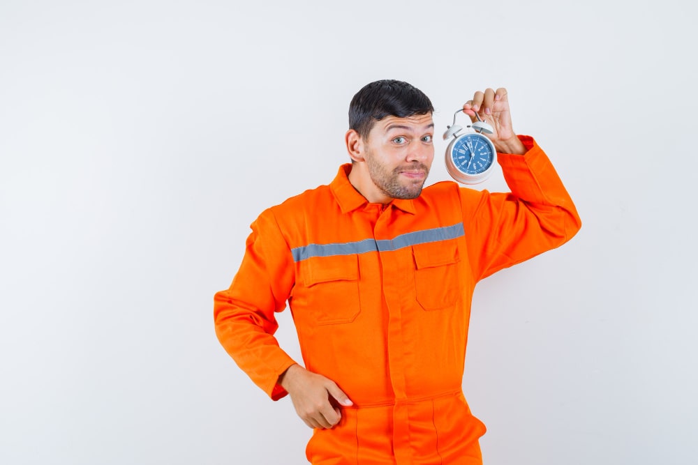 Engineer holding a clock while discussing service timing