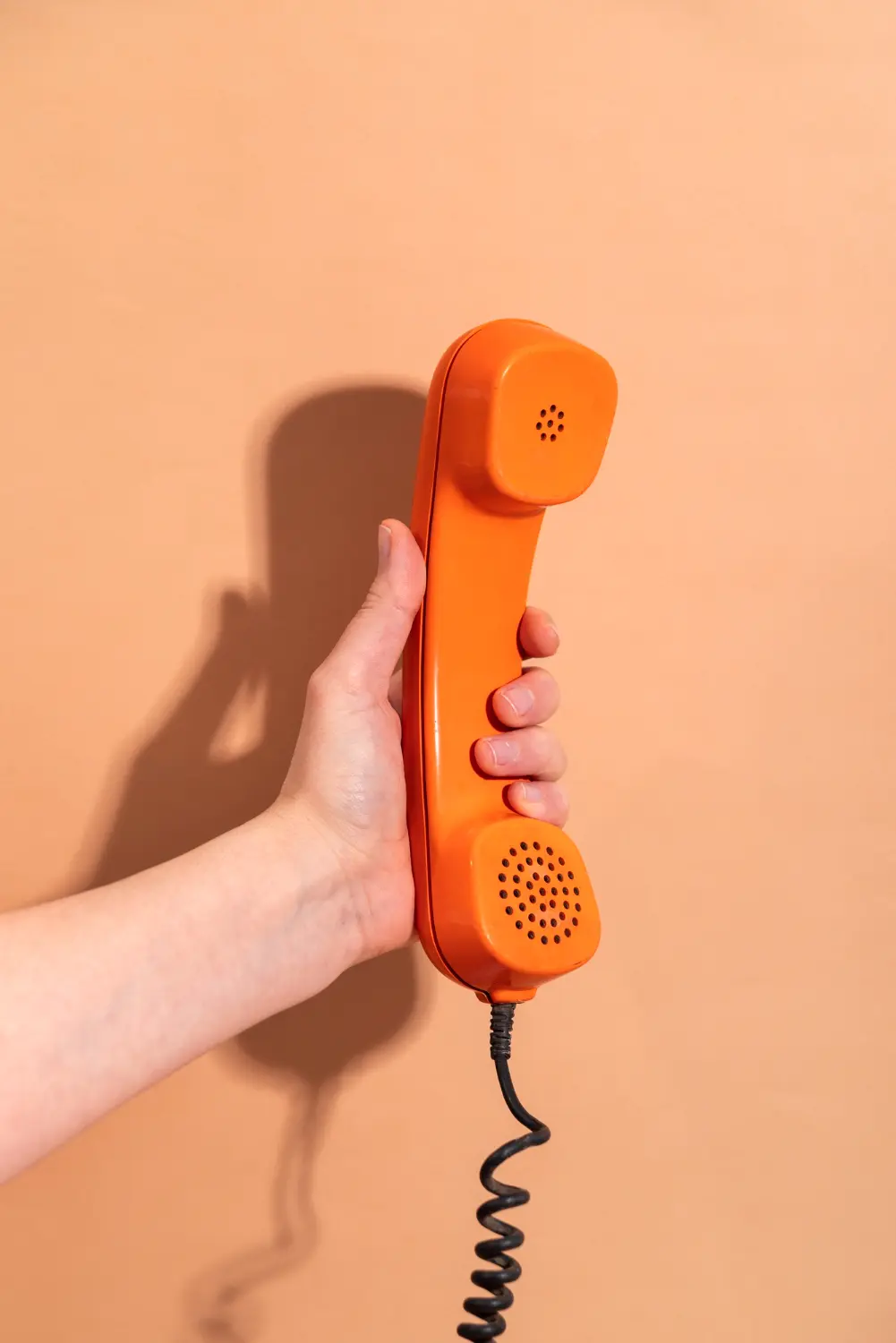 Hand holding a telephone handset ready for a service enquiry