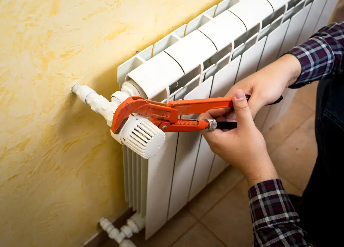 Engineer working on a radiator valve and control connection