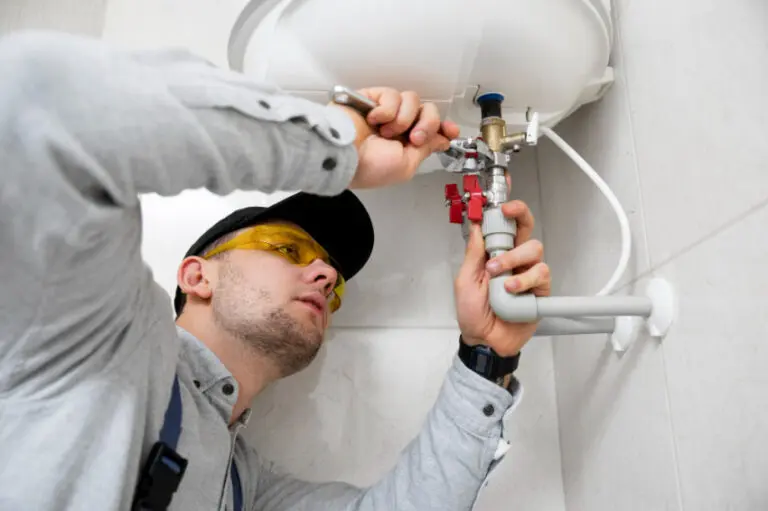 Engineer using a spanner on accessible heating and hot-water pipe connections