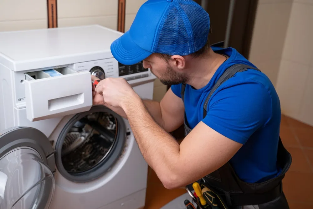 Technician checking the detergent drawer on a front-loading washing machine