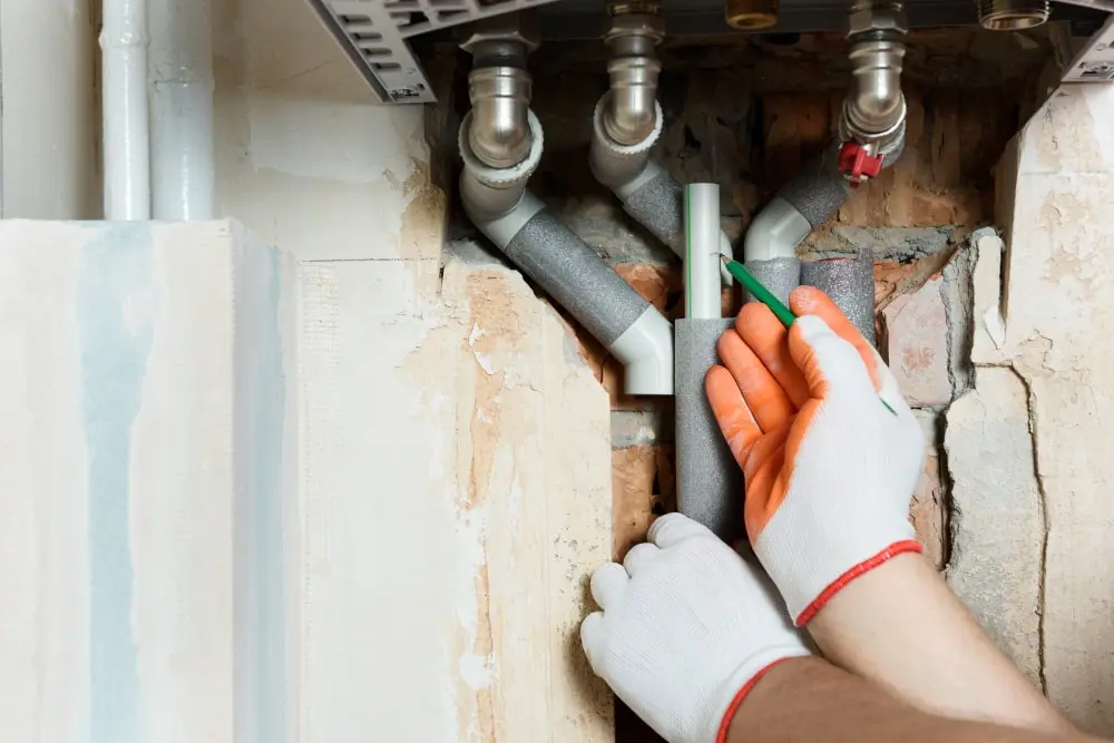 Plumber inspecting pipe connections during a tap repair in Guildford